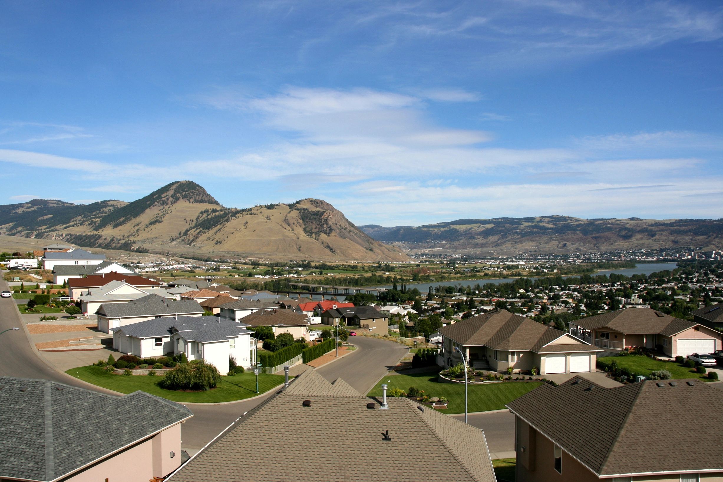 Typical Kamloops neighborhood with a mix of asphalt shingle and metal roofing, showing perfect sunlight exposure for residential renewable energy systems.